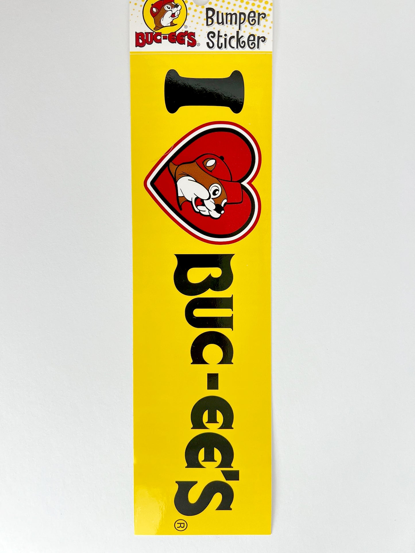 Standard 3x9 yellow I heart Buc-ee's bumper sticker with black lettering.