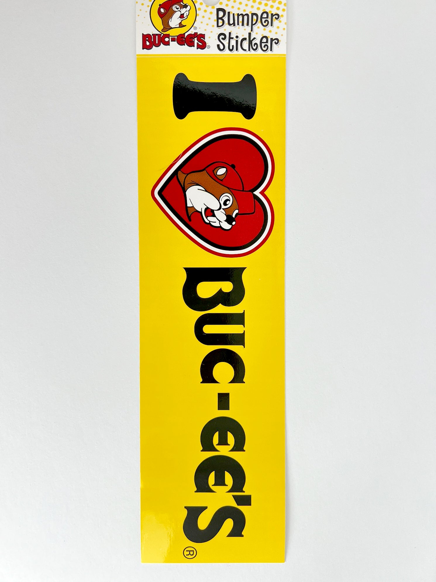 Standard 3x9 yellow I heart Buc-ee's bumper sticker with black lettering.